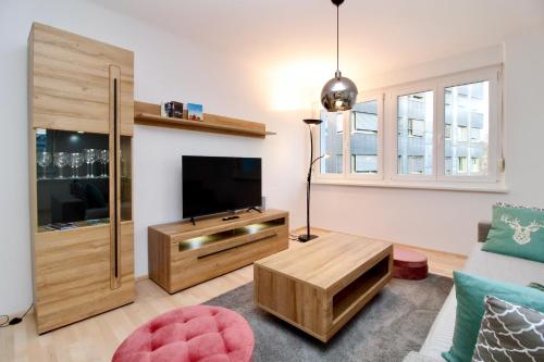 a living room with a flat screen tv and a couch at Graz central Penthouse Style Apt in Graz