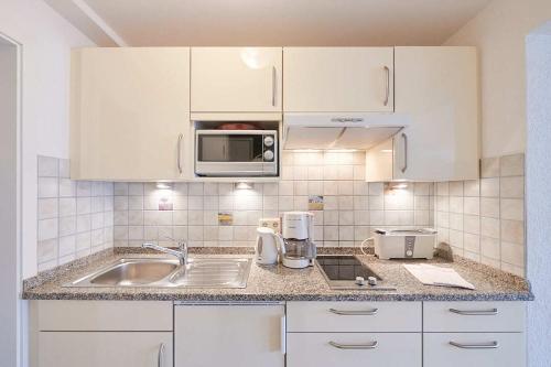 een keuken met een spoelbak en een magnetron bij Gästehaus Schiff in Meersburg