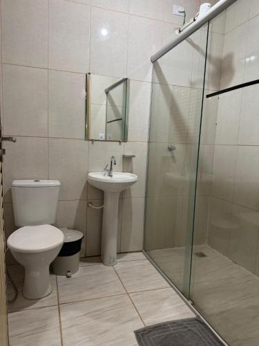 a bathroom with a toilet and a sink and a shower at Pousada Toca da Raposa in Cavalcante