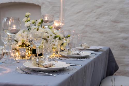 a table with plates and wine glasses and flowers at Teleki-Wattay Kastélyszálló in Pomáz