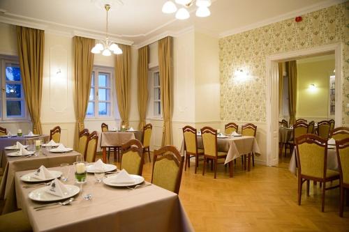 a restaurant with tables and chairs in a room at Teleki-Wattay Kastélyszálló in Pomáz