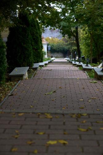 a brick path with benches in a park at Teleki-Wattay Kastélyszálló in Pomáz