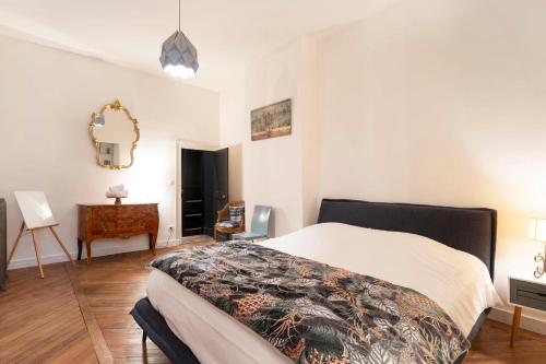 une chambre avec un lit, une table et un miroir dans l'établissement Le Mozart, à Nancy