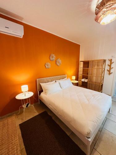 a bedroom with a large bed with an orange wall at Grace Home in Tricase