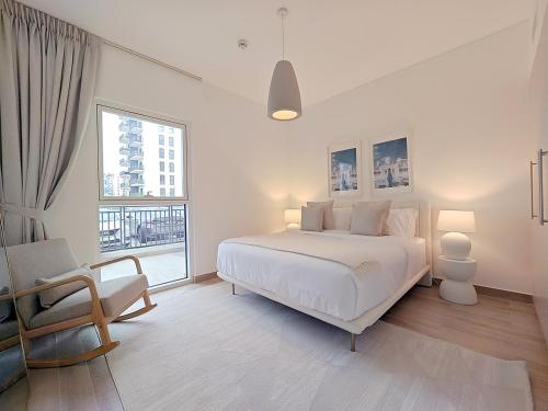 a white bedroom with a large bed and a window at Otolo Homes with Free Yas Theme Park Tickets in Abu Dhabi
