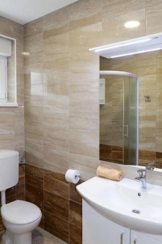 a bathroom with a white sink and a toilet at Holiday Home Amaya in Vrgorac