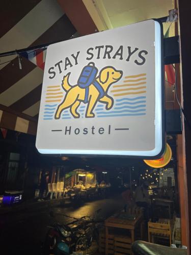 a sign for a stay stays hotsetter in a restaurant at Stay Strays Hostel in Bangkok