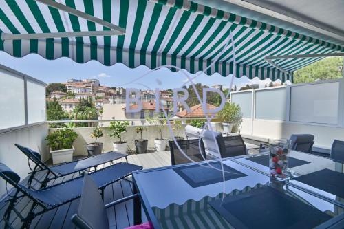 d'une terrasse avec des tables et des chaises bleues sur un balcon. dans l'établissement Beautiful apartment in the heart of Cannes' little Juas, à Cannes