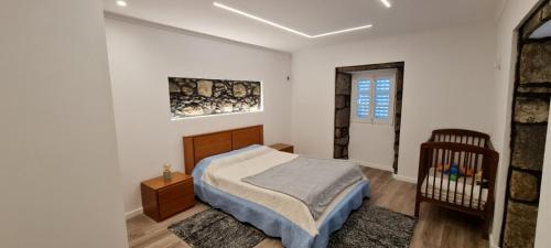 a bedroom with a bed and a crib in it at Casa Miramar in Algarvia