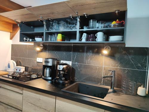 a kitchen with a coffee maker and a sink at Gîte du jardin de pierre in Pléhédel