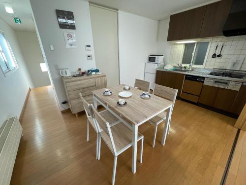 a kitchen with a table and chairs in a room at Hakodate cozy house w/parking in Hakodate