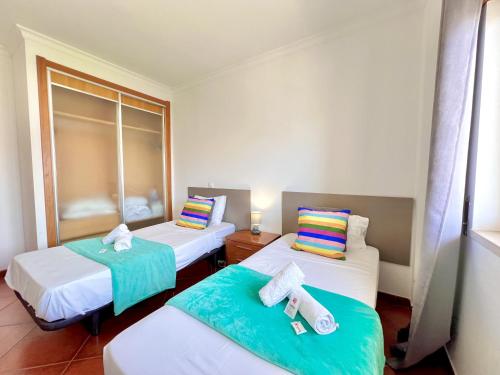 een kamer met twee bedden met handdoeken erop bij Albufeira Modern 6 With Pool by Homing in Vale de Pedras