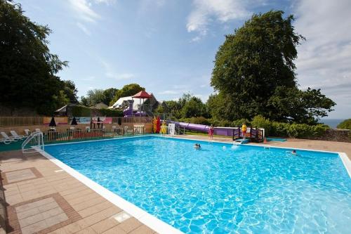 a large blue swimming pool with a water slide at Bay View Villas in Bucks Mills