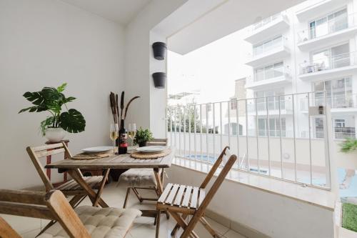 a dining room with a balcony with a table and chairs at Family duplex apartment w shared pool by Homely in Mellieħa