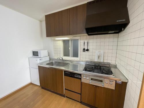 a small kitchen with a sink and a stove at Hakodate cozy house w/parking in Hakodate