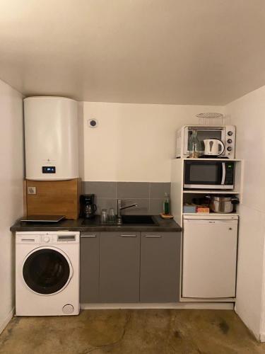 Il comprend une petite cuisine équipée d'un lave-linge et d'un four micro-ondes. dans l'établissement Appartement Atypique Cosy et Hyper Centre Paris 10eme près du Canal Saint-Martin, à Paris