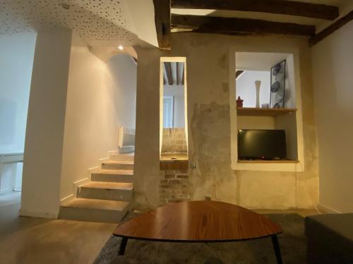un salon avec une table et une télévision dans l'établissement Appartement Atypique Cosy et Hyper Centre Paris 10eme près du Canal Saint-Martin, à Paris