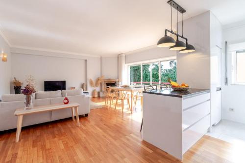 a kitchen and living room with a couch and a table at Seaside Urban Retreat – 5min to Esposende Beach in Esposende
