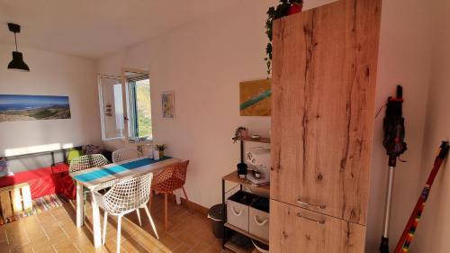 ein Wohnzimmer mit Tisch und Küche in der Unterkunft Casa Emma in San Nicola Arcella