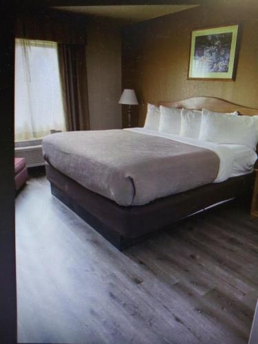 a bedroom with a large bed with white pillows at Quality Inn in Perrysburg