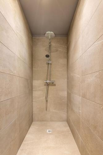 a shower with a shower head in a bathroom at Suite & Spa Le Clandestin ARRAS in Arras