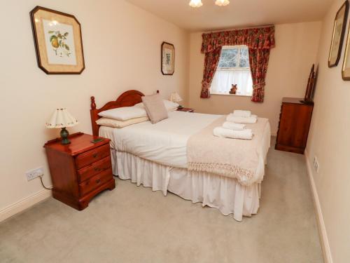 a bedroom with a bed and a table with towels on it at Hollyhock in Wooler