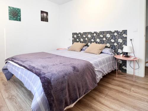 1 dormitorio con 1 cama con manta morada y mesa en Regimiento 2, center, new, quite, parking on request, RG, en Málaga