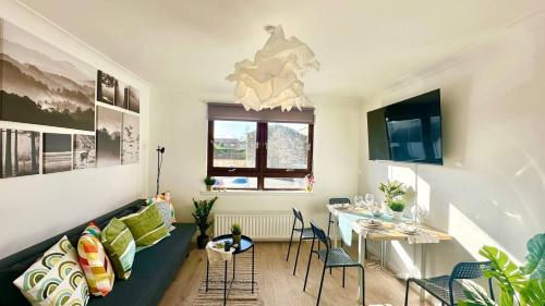 a living room with a couch and a table at Cosy stylish Duntocher flat near Glasgow in Clydebank
