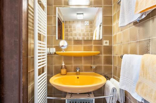 a bathroom with a yellow sink and a mirror at Haus Aretz in Feldberg
