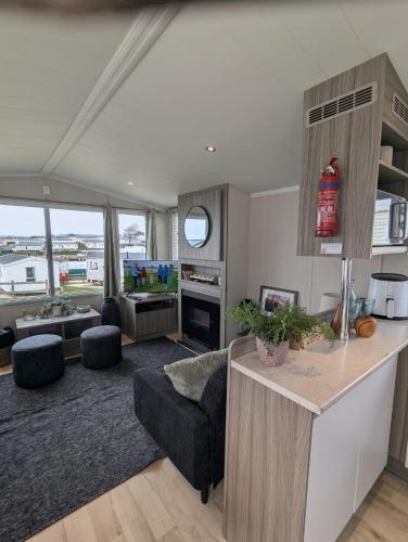 a living room with a kitchen and a living room with a couch at BEAUTIFULLY PRESENTED DOG FRIENDLY CARAVAN on VERY POPULAR LITTLESEA HOLIDAY HAVEN PARK WEYMOUTH in Weymouth