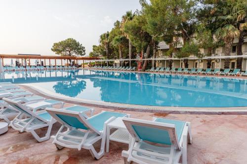 a large swimming pool with chairs and a hotel at Fun & Sun Club Saphire in Tekirova