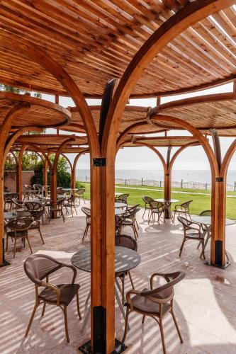 a wooden pergola with tables and chairs on a patio at Fun & Sun Club Saphire in Tekirova