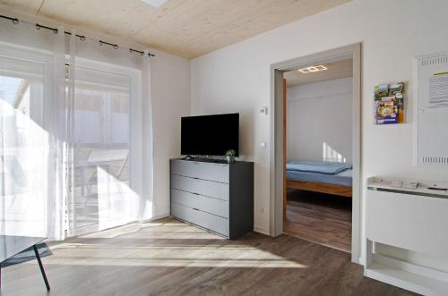 a living room with a tv and a dresser with a television at Schwäbische Alb 2 in Albstadt