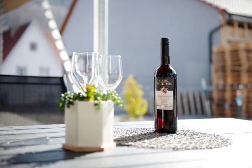 a bottle of wine sitting on a table with two wine glasses at Schwäbische Alb 2 in Albstadt