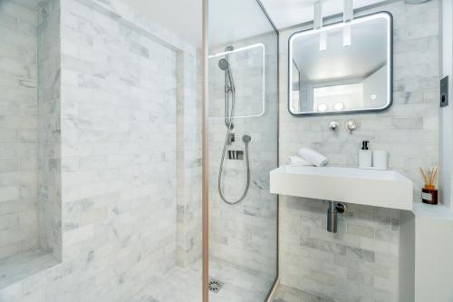 une salle de bain avec douche et lavabo dans l'établissement Luxury and Elegance Louvre - Rivoli, à Paris