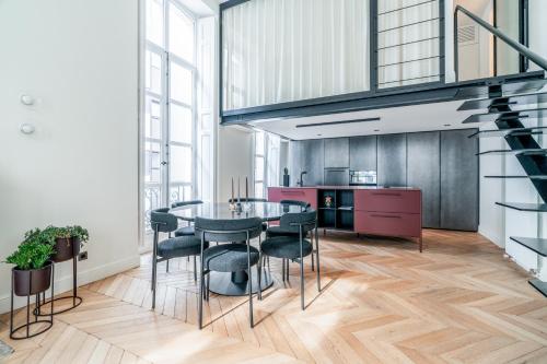 une cuisine et une salle à manger avec une table et des chaises dans l'établissement Luxury and Elegance Louvre - Rivoli, à Paris