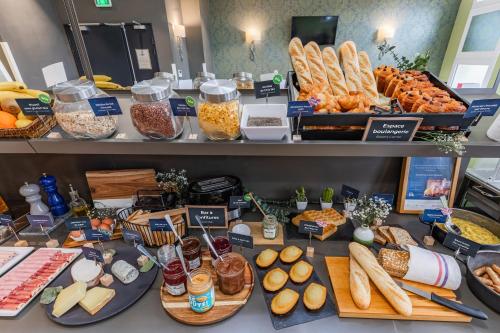a buffet with bread and other food items on display at Appart'City Collection Paris Grande Bibliothèque in Paris
