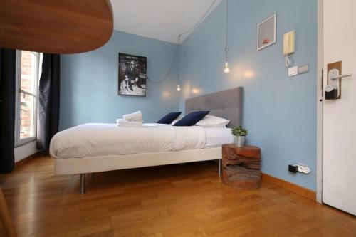 - une chambre avec un lit blanc aux murs bleus dans l'établissement 405 - sejour romantique dans un studio de Paris 5, à Paris