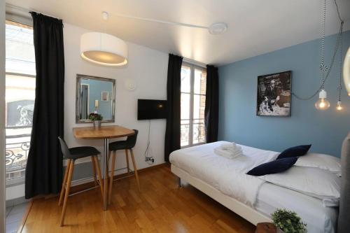 une chambre avec un lit, une table et un bureau dans l'établissement 405 - sejour romantique dans un studio de Paris 5, à Paris