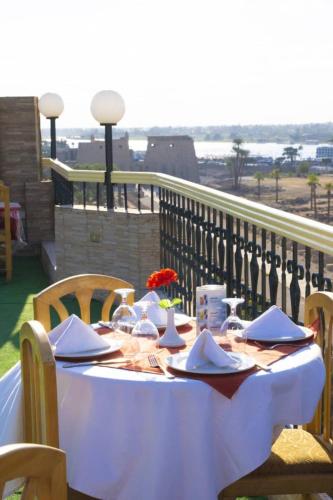 a table with plates and napkins on a balcony at Queens Valley Hotel in Luxor