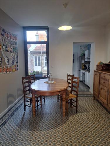 une table de salle à manger et des chaises dans une pièce dans l'établissement L'Iris au cœur de Corbie pour 4 pers, à Corbie