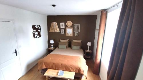 une chambre avec un lit et une grande fenêtre dans l'établissement Home Emoi, à La Gouesnière