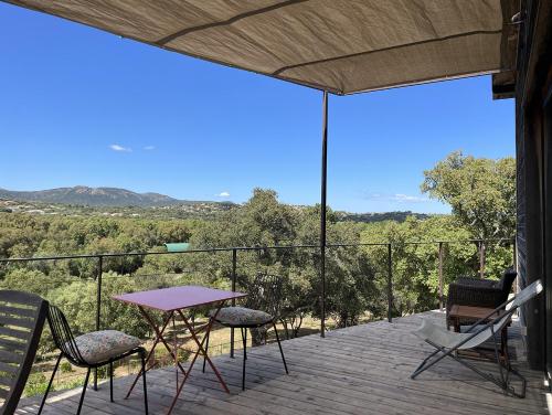 a table and chairs on a deck with a view at A Casuccia in Zonza