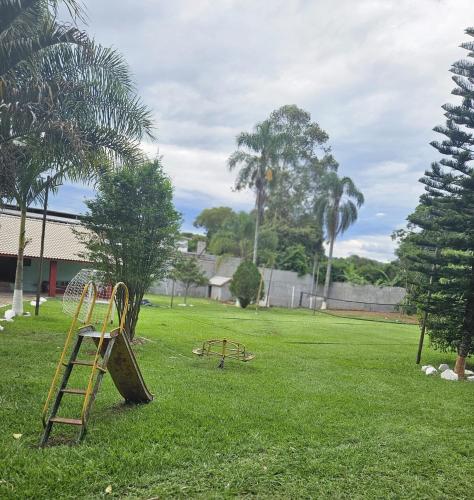a park with two play equipment in the grass at Chácara Falcão in Itapeva