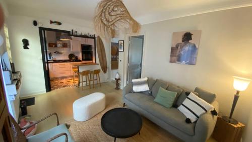 un salon avec un canapé et une table dans l'établissement T3 avec patio Grande Plage Biarritz, à Biarritz