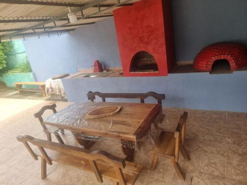 a dining room with a table and a pizza oven at Chácara Falcão in Itapeva