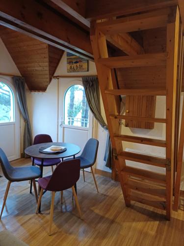 une pièce avec une table, des chaises et un escalier dans l'établissement Calmos Cottage, à Barneville-Carteret