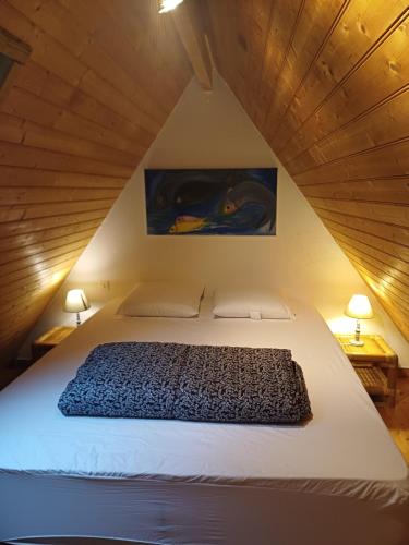 - une chambre mansardée avec un lit et 2 lampes dans l'établissement Calmos Cottage, à Barneville-Carteret