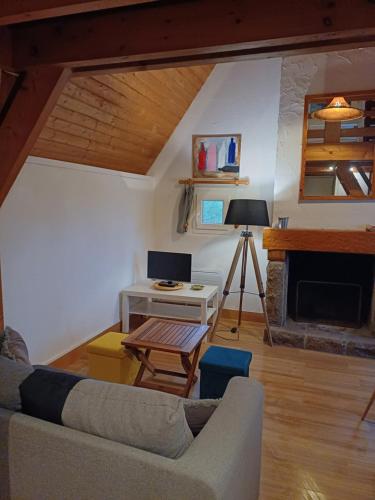un salon avec un canapé et une cheminée dans l'établissement Calmos Cottage, à Barneville-Carteret