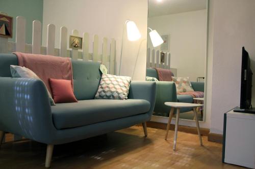 a living room with a blue couch and a tv at La Colombière - Vue imprenable sur l'Ardèche - Très Calme - Très bien situé - Résidence Privée in Montélimar